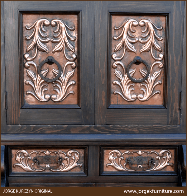 Close-up of hammered copper panels with floral tooling and iron rings