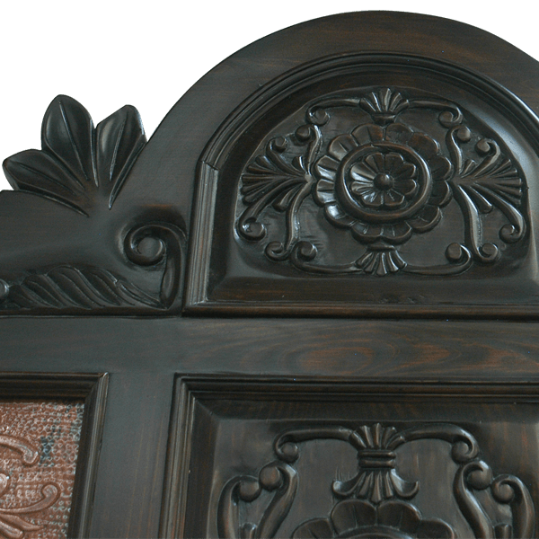 Detail of hand-carved wood scrolls and copper floral tooled panels