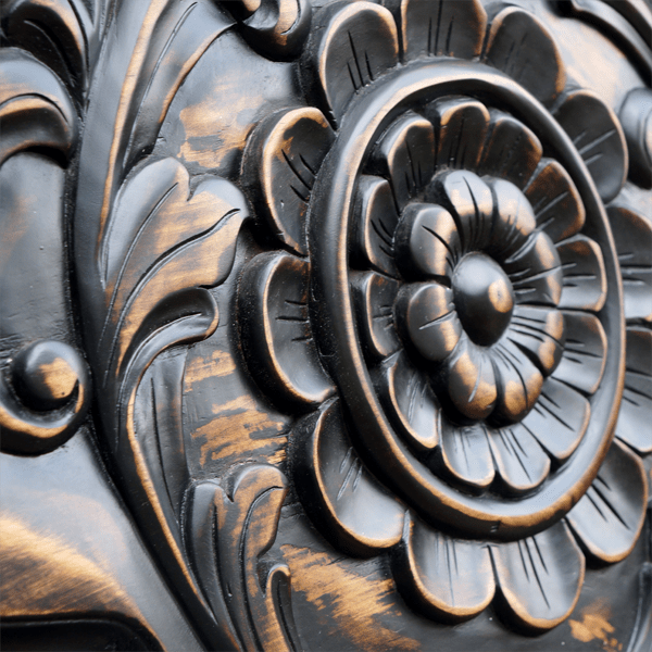Detail of central flower carving with scroll border on handcrafted wood