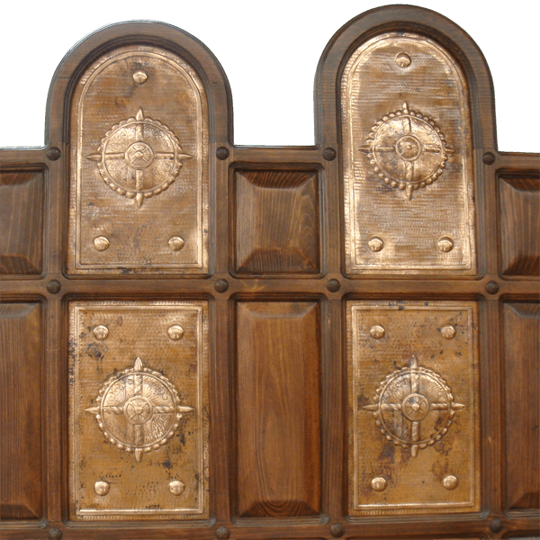 Close-up of hammered copper panels with star motifs and hand-forged iron nails on Spanish colonial headboard