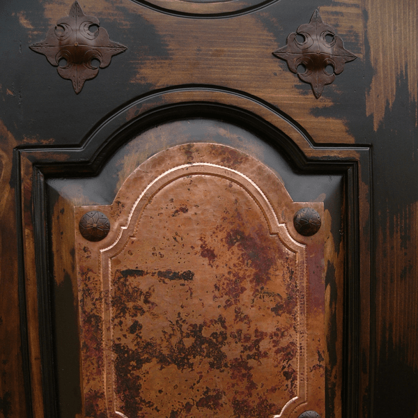 Detail of hammered copper panel with tooled border and forged iron conchos on Spanish colonial bed