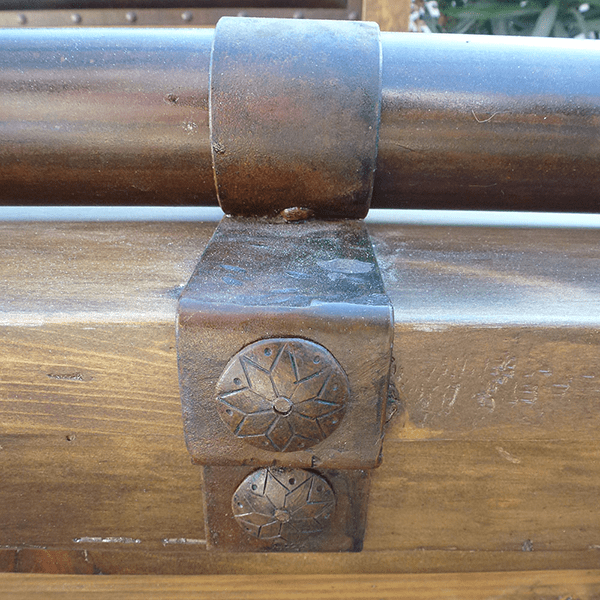 Detail of forged iron accents and wood finish on Western-style bed footboard