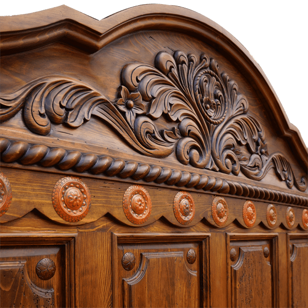 Detail of carved crest with twist rope and copper conchos on Spanish colonial bed