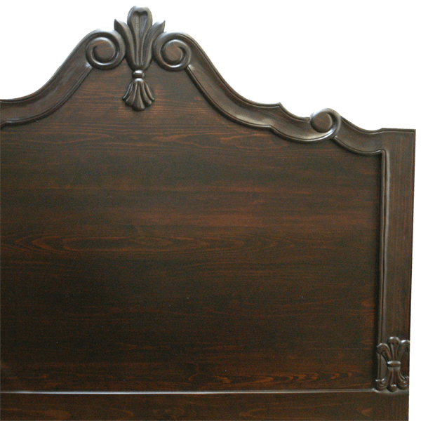 Detail of headboard with floral and scroll carving in dark wood