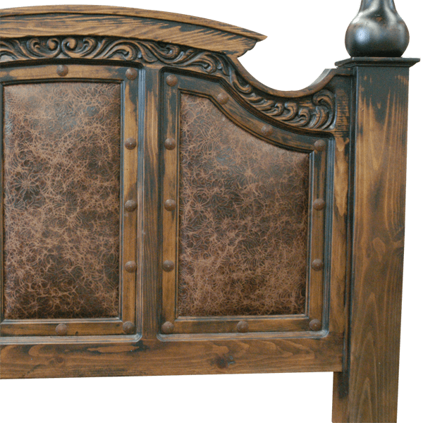 Detail of footboard with dark leather panels, floral scroll carving, and iron conchos