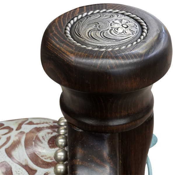 Detail view of Saddle Turquesa bar stool showing concho, wood tone, hand tacks, and embossed leather