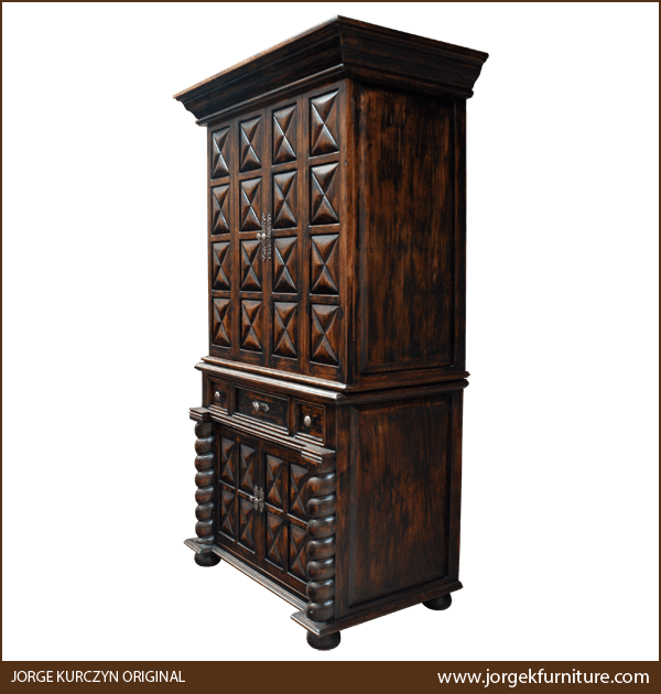 Handcrafted Spanish colonial armoire with hand carved designs, drawers, and bun feet, three-quarter view